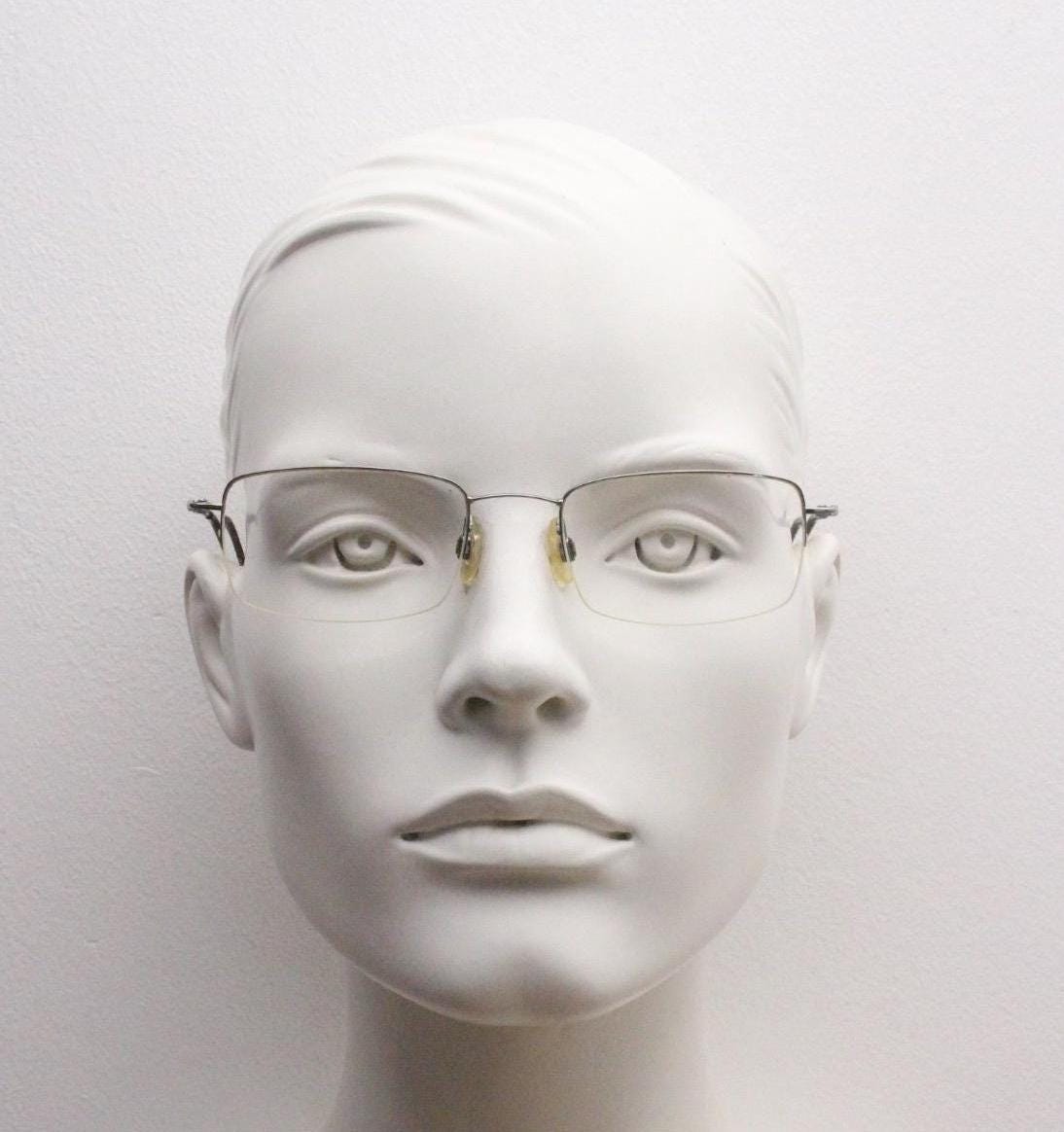A mannequin head wearing a pair of glasses against a plain white background.