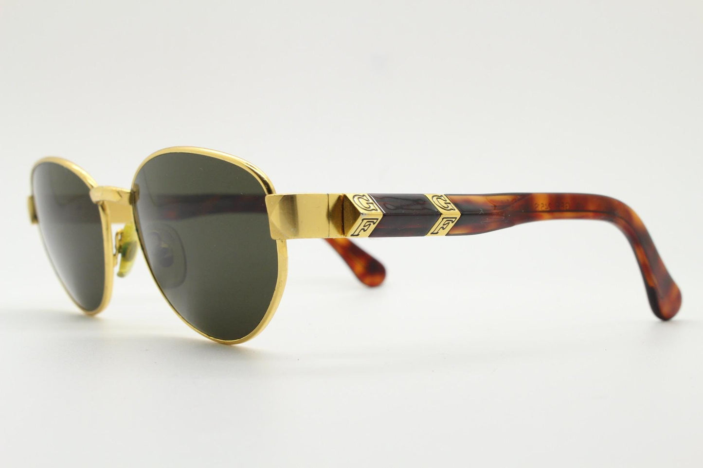 Gianfranco Ferre oval sunglasses made in Italy. Gold frame with triangular tortoise acetate arms and green lenses. 90s vintage GFF