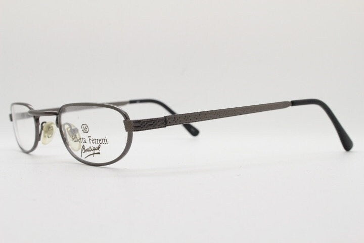 Alberta Ferretti 90s vintage oval eye glasses made in Italy. Small grey metal optical frame with ornate arm pattern. Prescription RX. NOS