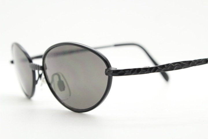90s vintage oval sunglasses. Minimal plain matt black metal frame with unusual indented arm patterns. Unused NOS