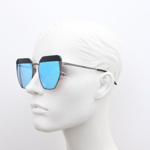 For Arts Sake angular cat eye hand made sunglasses. Black flat top 'eyebrow' design with blue mirror lenses and gunmetal grey frame