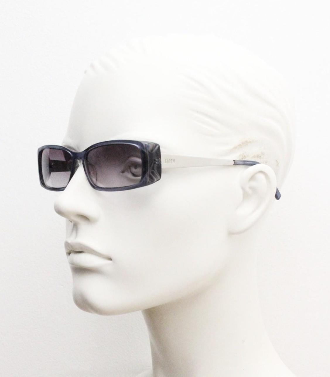 90s vintage rectangular low profile sunglasses by Storm. Transparent grey acetate front with brushed steel arms. NOS. 2000s
