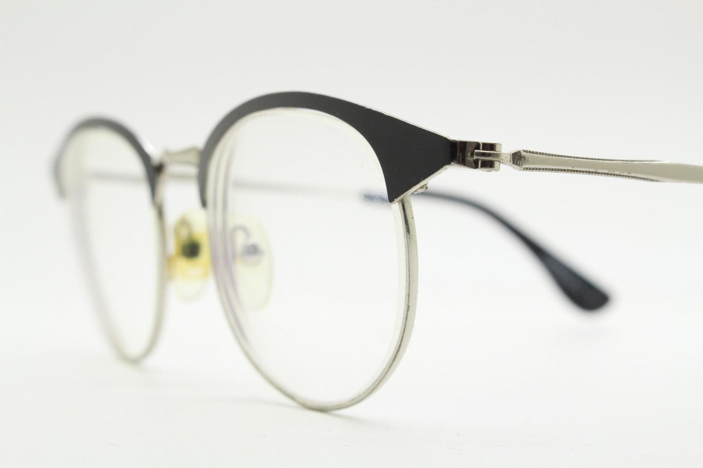 Lupo and Co round eye glasses with pointed corners. Flat metal silver optical frames with black browline. Prescription eyeglasses. RX