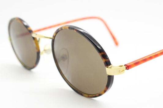 90s vintage oval sunglasses. Handsome honey tortoise and blazing amber arm combo on a slender metal frame. NOS
