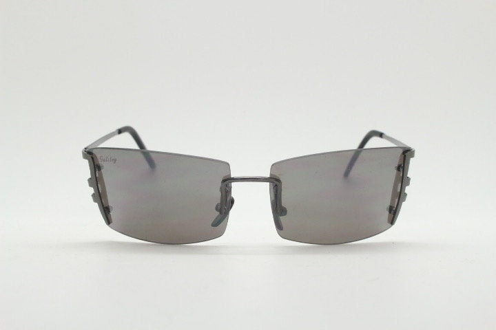 Y2K vintage wraparound sunglasses. Dynamic frameless shield design in gunmetal grey with slight mirror glaze rectangular lenses. 2000's NOS