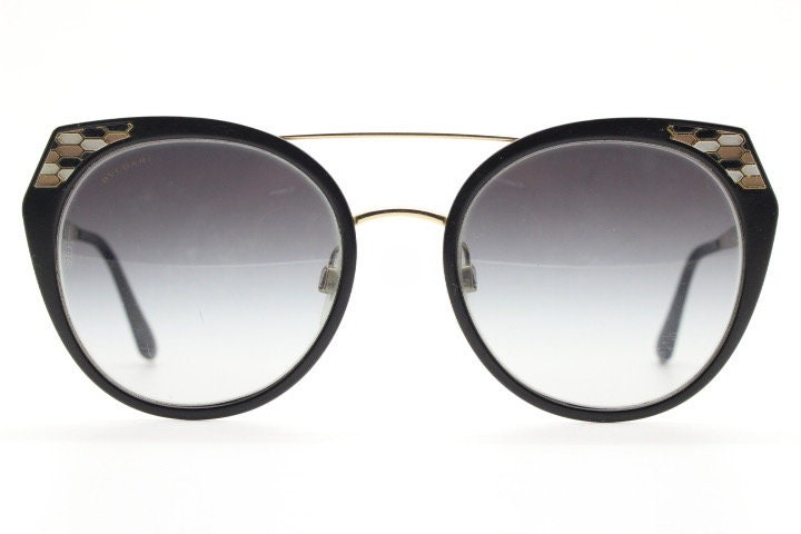 Bulgari round cropped cat eye sunglasses made in Italy. Womens black and gold frame with honeycomb patterns and smoky graduating lenses