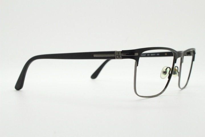 Calvin Klein rectangular eye glasses. Gunmetal grey chrome wire optical frames with black matt brow. Prescription eyeglasses. RX Spectacles