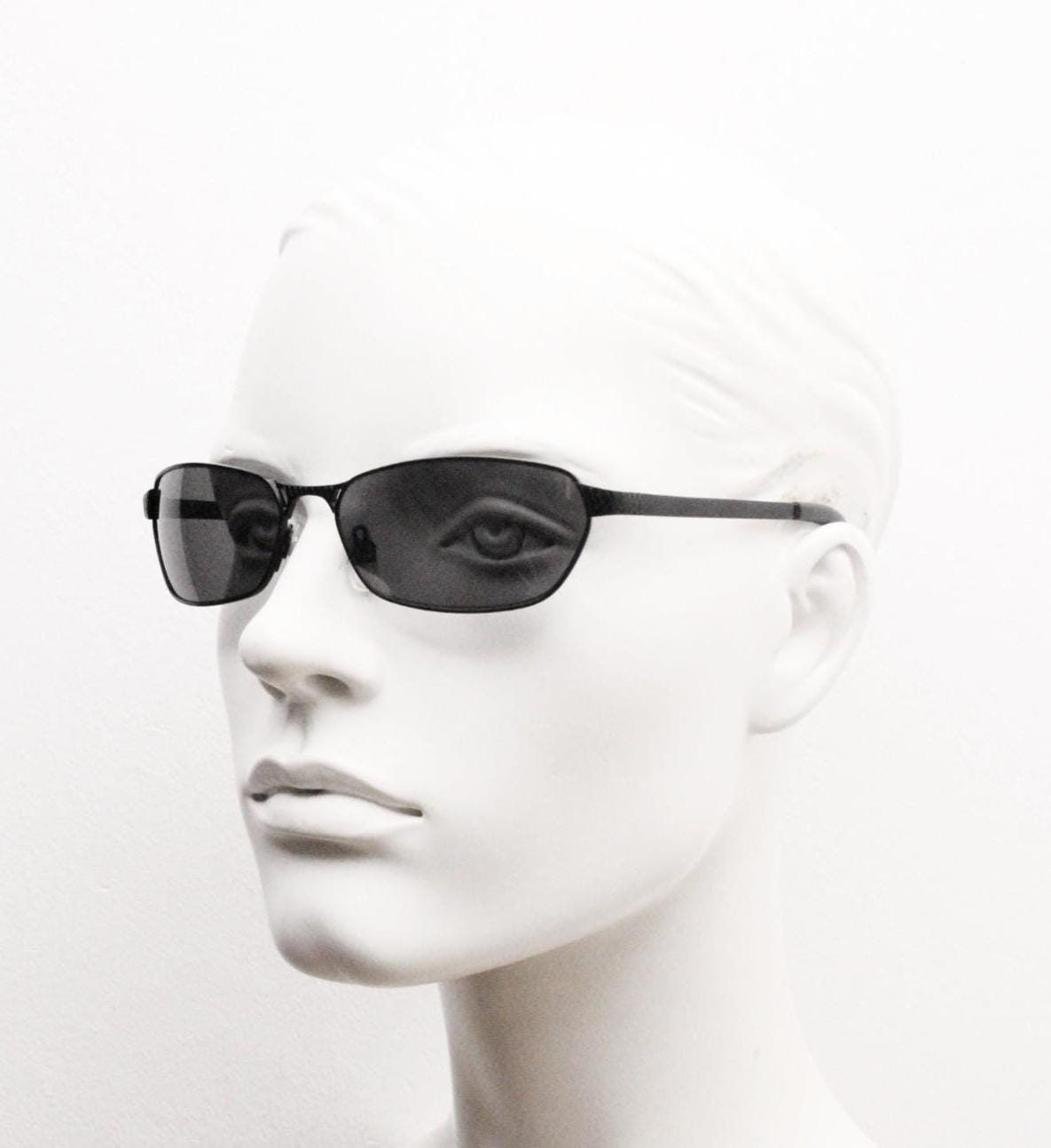 90s vintage wraparound sunglasses. Black satin finish on rectangular frame with unassuming style details. 2000's. Y2K. Unused NOS bug eye
